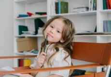 Enfant pensif avec stylo, exprimant ses émotions et sa réflexion.